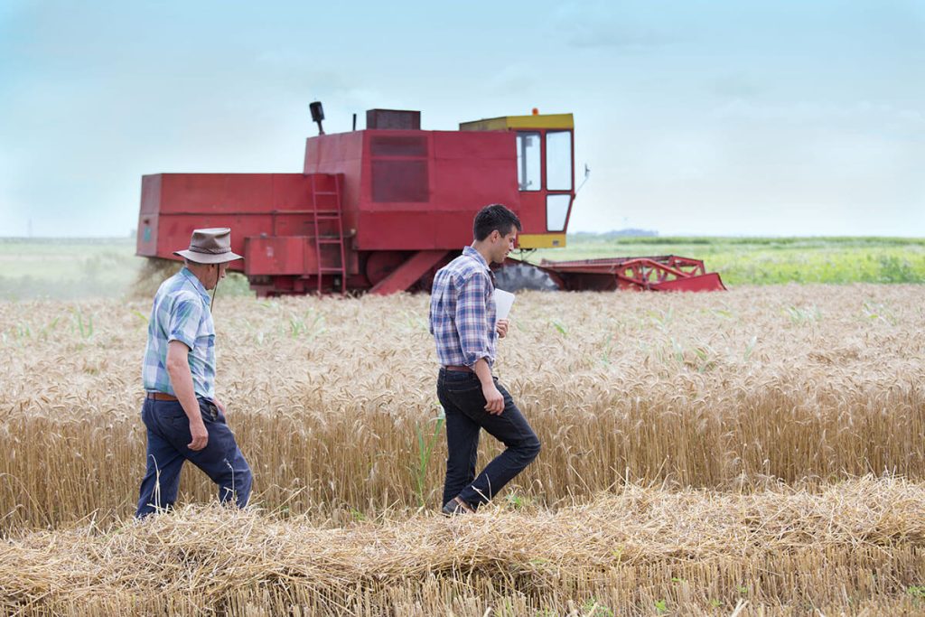 farmers on field with farming equipment