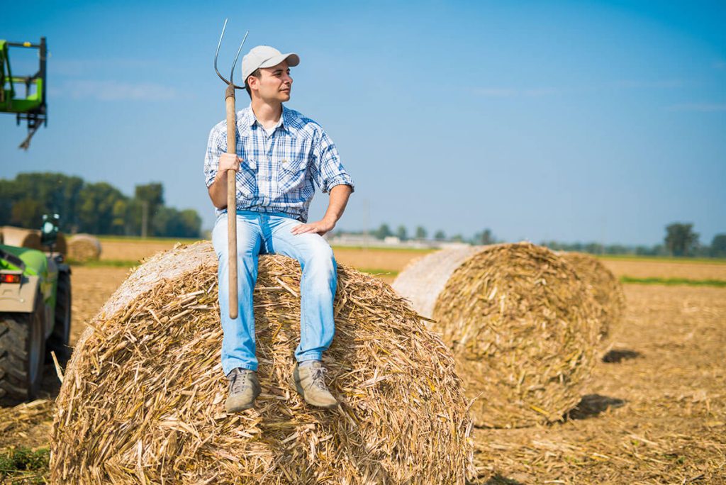 farmer sitting on a hay ball